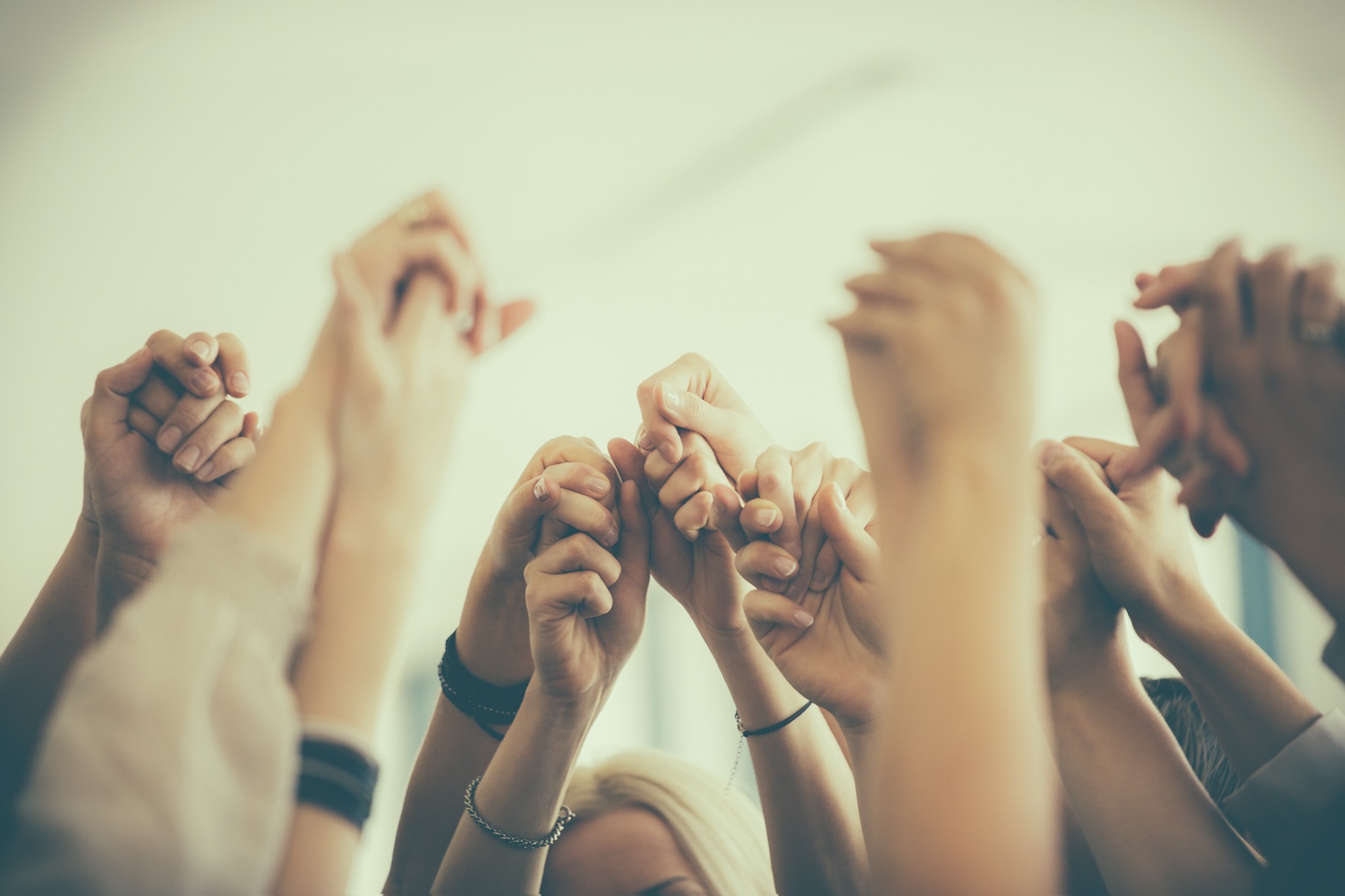 A group of women raising joined hands together